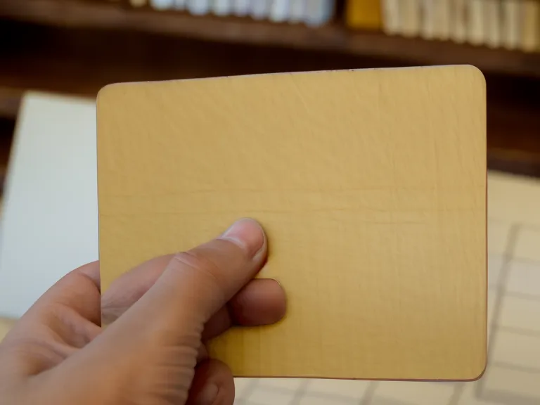 Hand sortiert eine handbeschriebene Karteikarte in den gelben Karteikasten während der Ahnenforschung ohne Dokumente